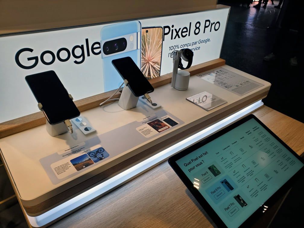 Interactive Google Pixel display stand in front of two screens in a shop