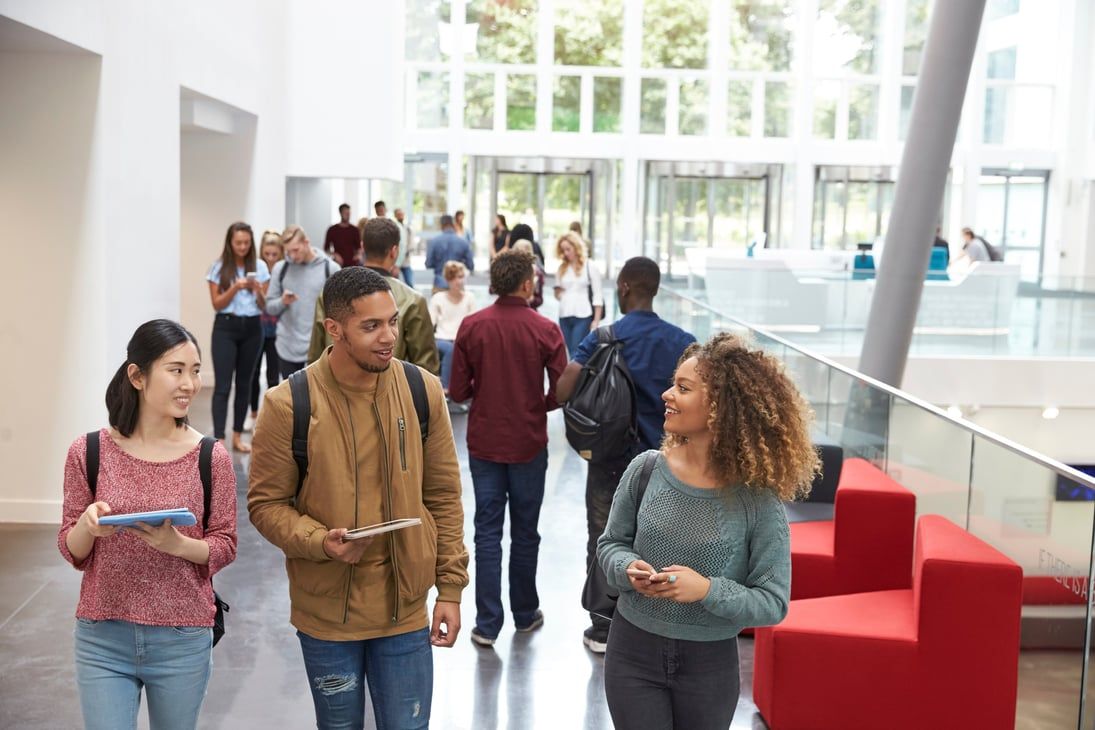 Students talking together in the bright hall of a university building