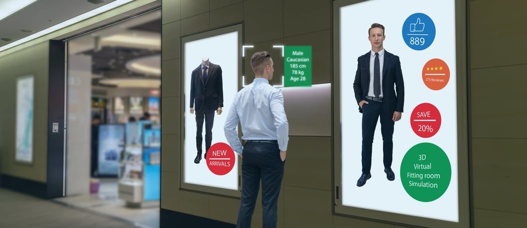 Shoppers walking past large advertising screens in a shopping centre
