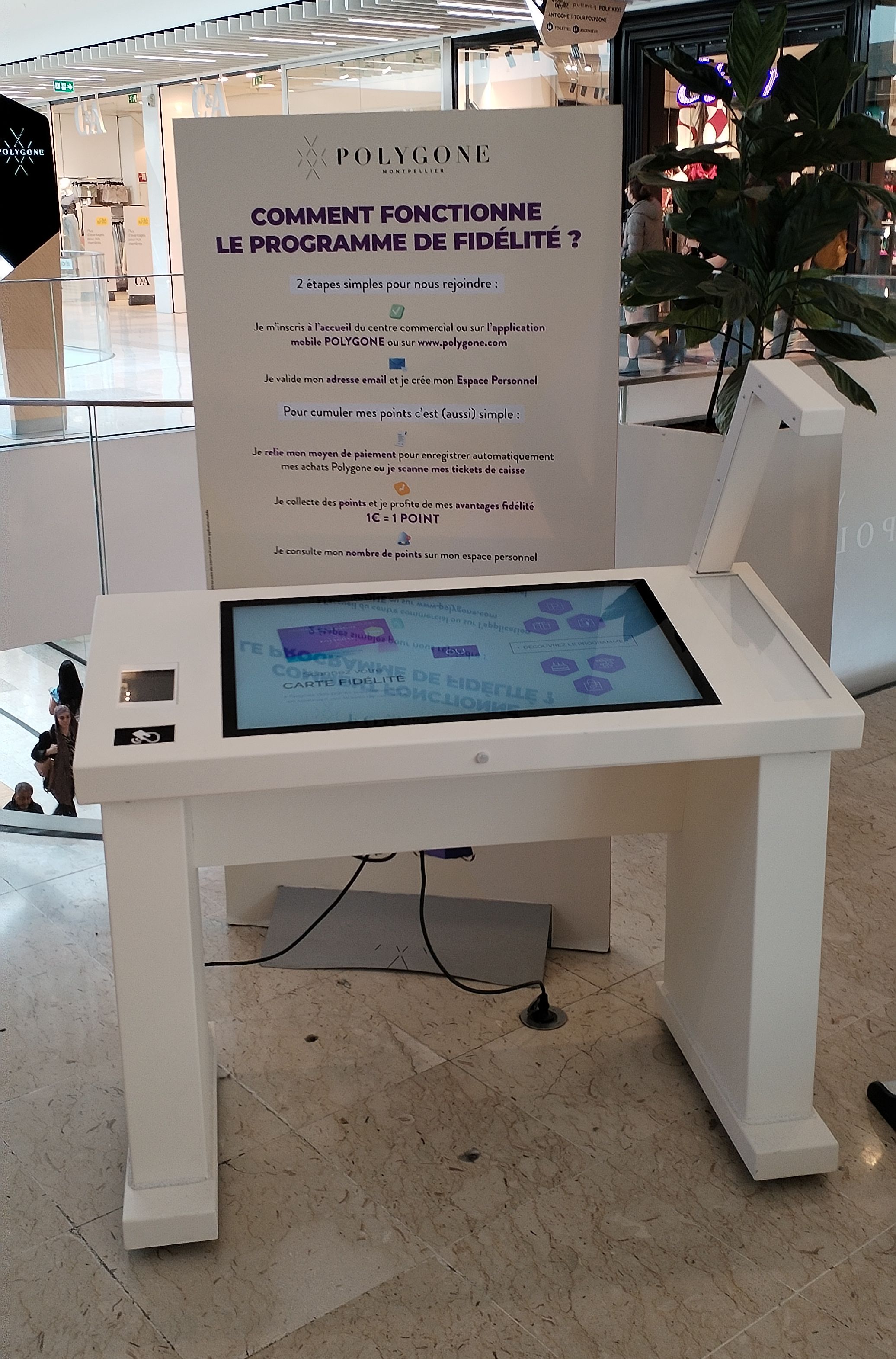 The loyalty terminal in front of the panel explaining the loyalty program