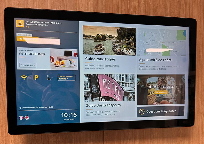 Écran tactile 32" affichant l'application de l'hôtel