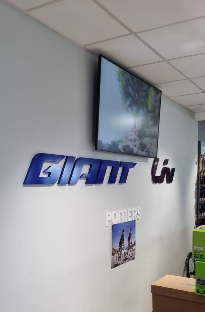 Écran d'affichage dynamique diffusant les marques Giant et Liv en magasin
