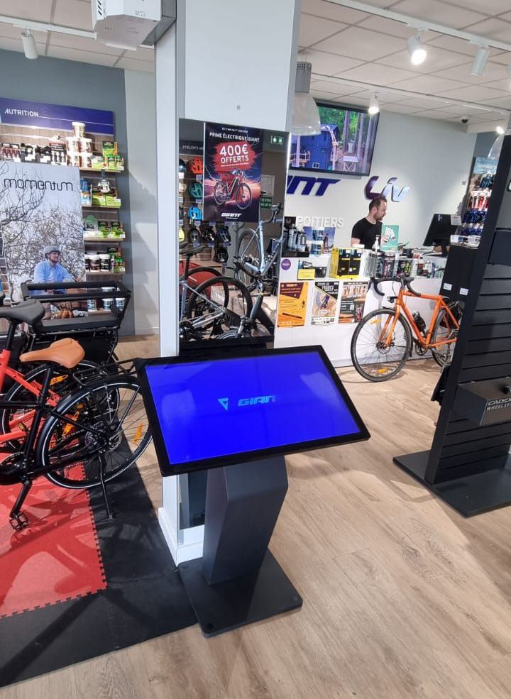 Borne tactile Touchify devant un vélo Giant en magasin