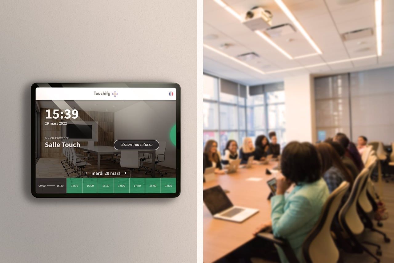 A meeting room with a booking display mounted outside