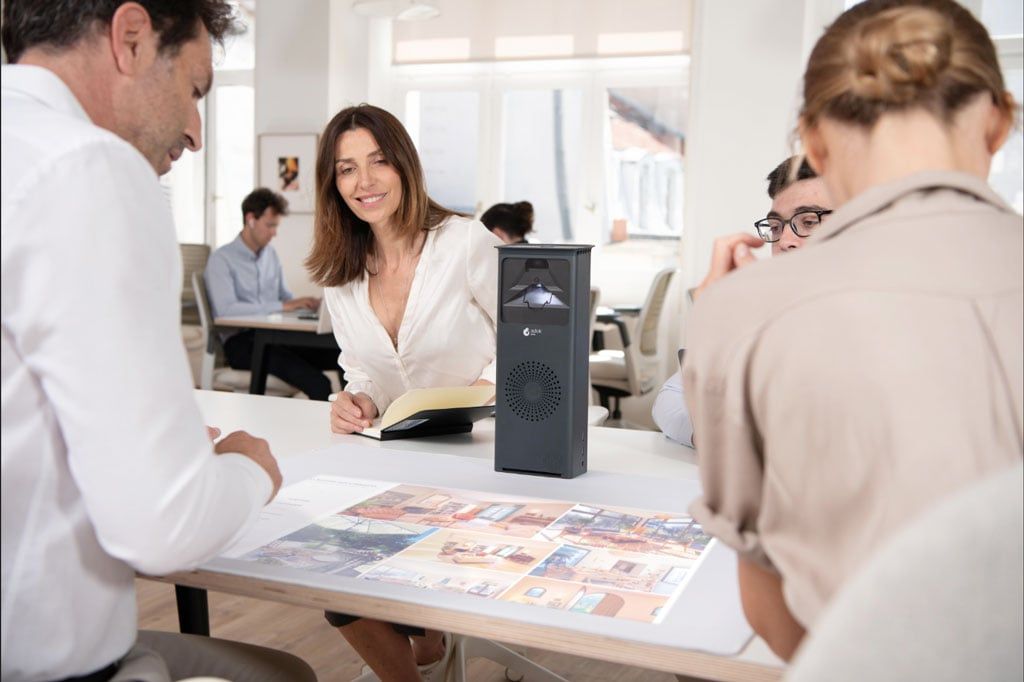 Colleagues gathered around a table fitted with the Adok touch hub