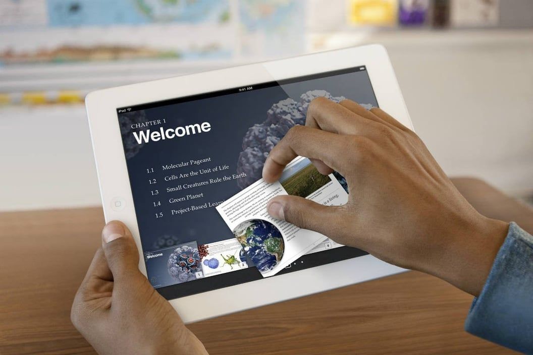 Hands using a tablet showing an interactive welcome menu