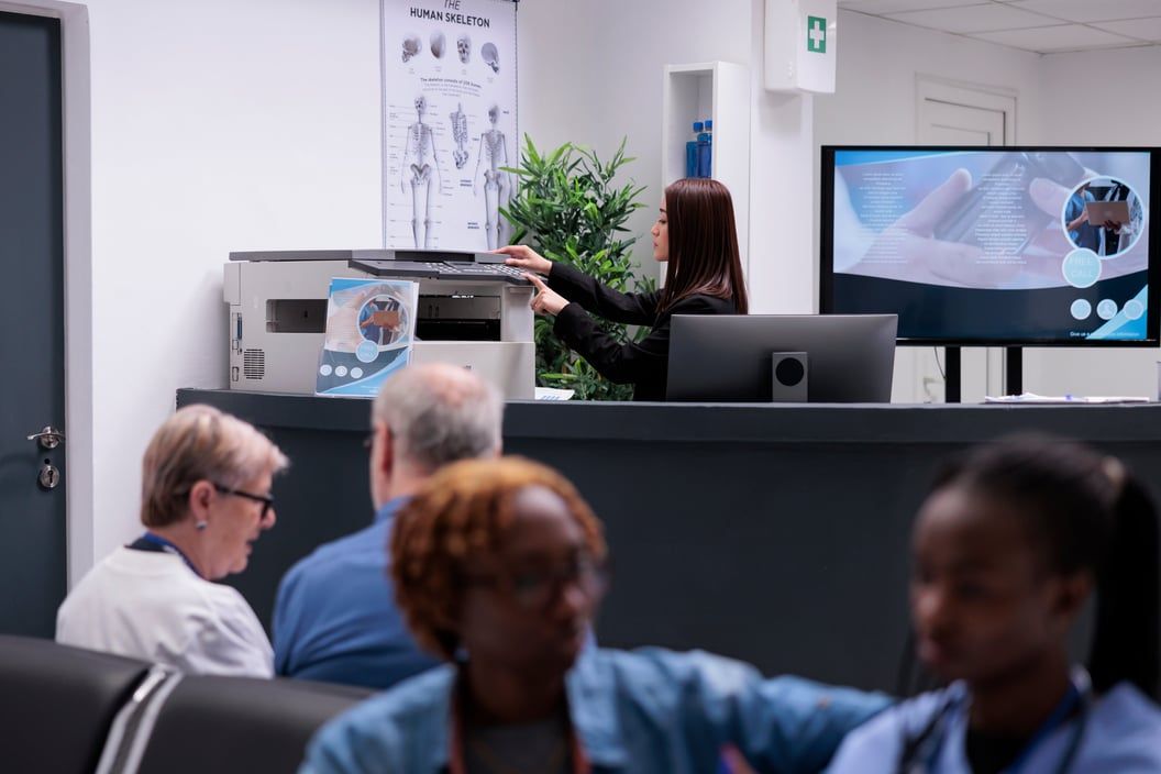 Réceptionniste à l'accueil d'un hôpital, devant un écran d'ordinateur